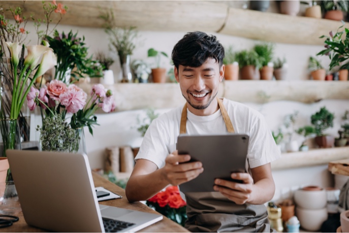 Merchant on a tablet in a flower shop.