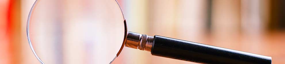 A magnifying glass on a wooden floor.