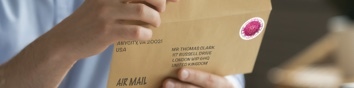 Person preparing to send a letter using First-Class Mail International service.