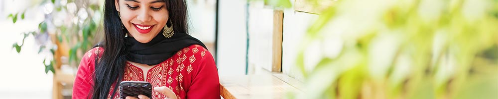 A woman on her smartphone smiling.